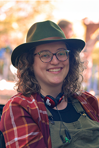 Jacqueline Davis in overalls and hat working on location.